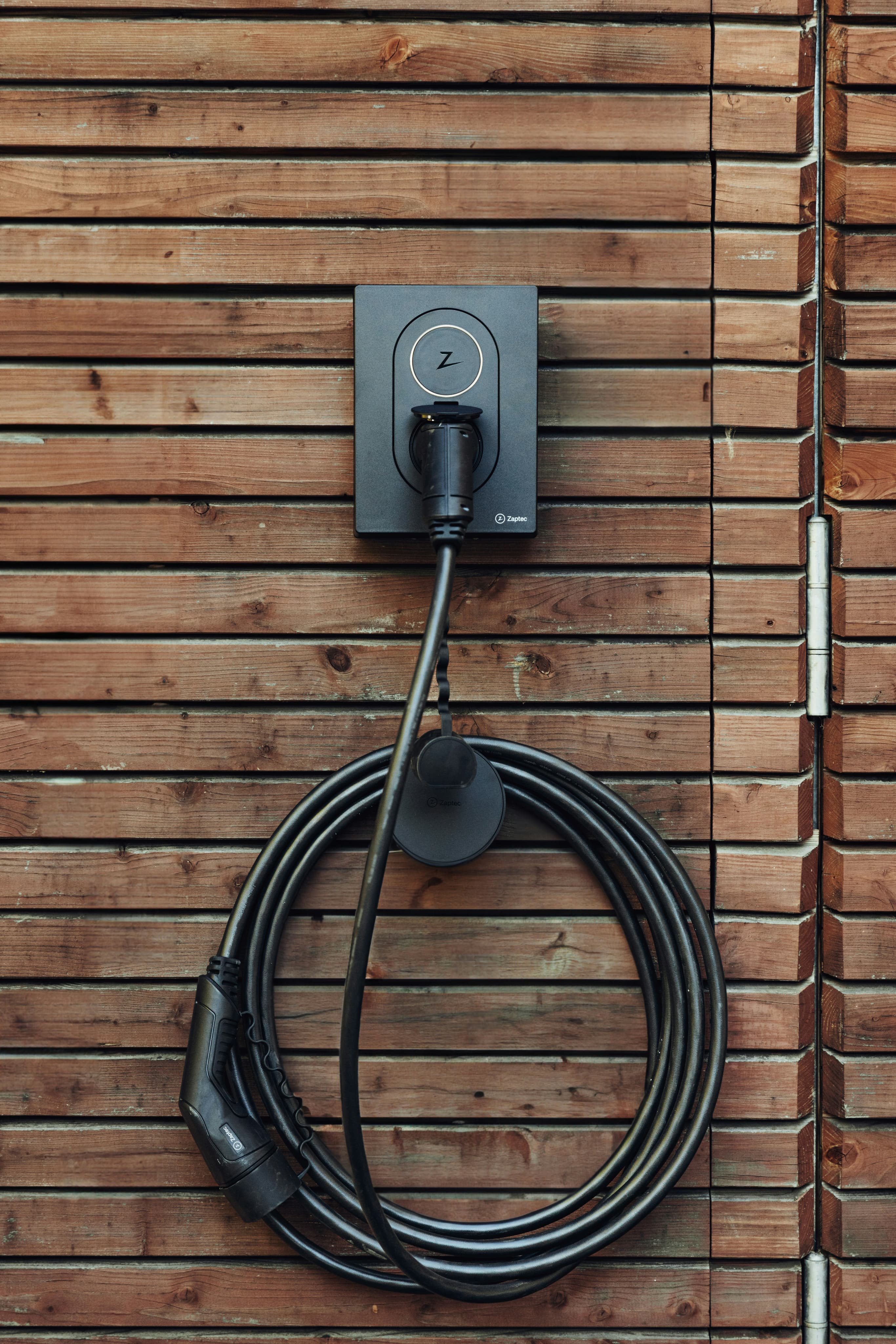 Wall-mounted EV charger on a wooden wall